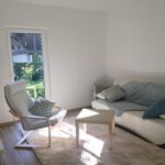 Wohnzimmer mit Couch und Sessel