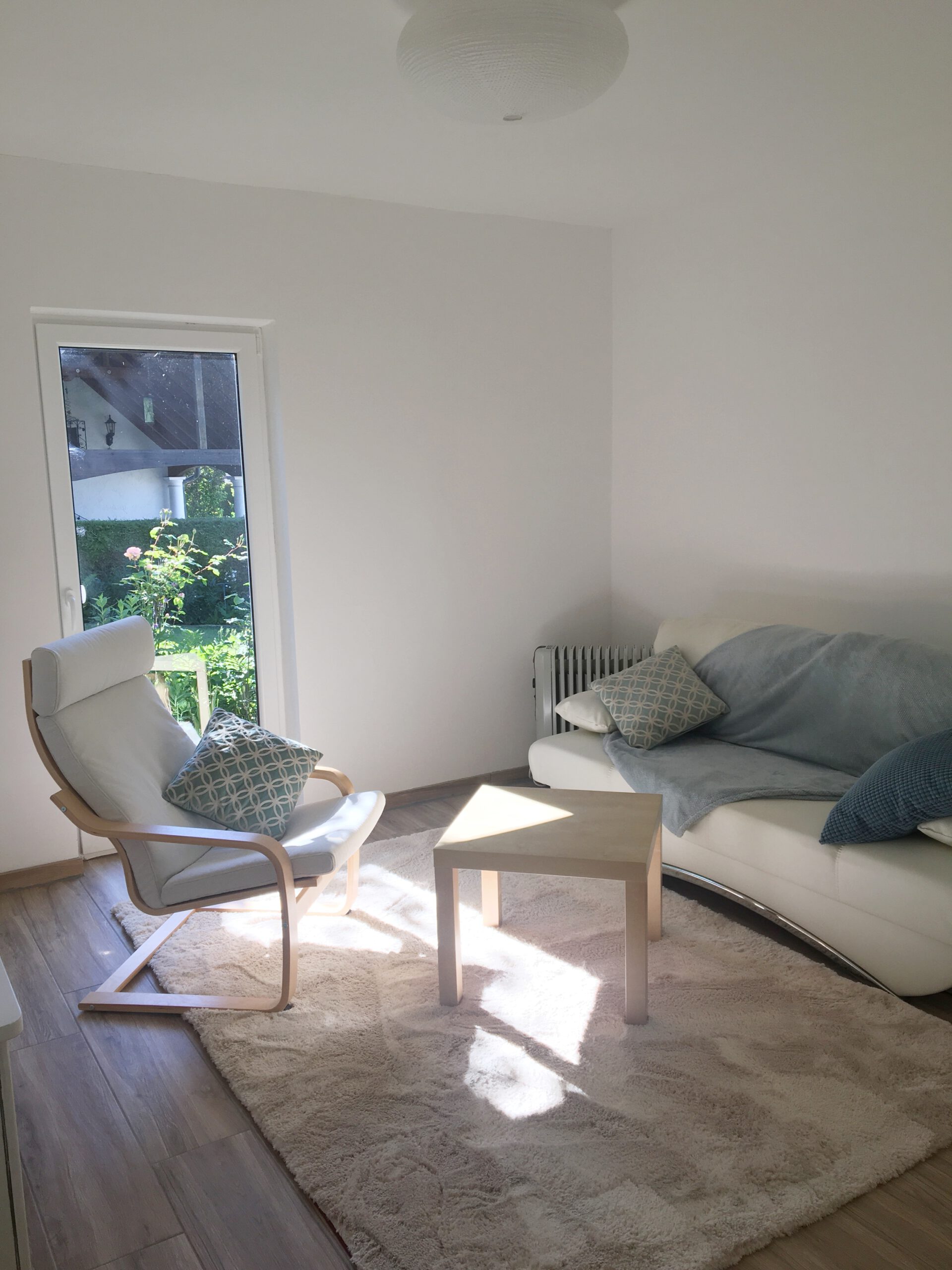 Wohnzimmer mit Couch und Sessel